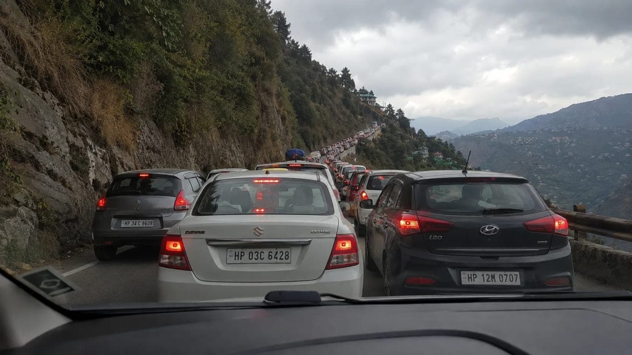 Heavy traffic on a narrow mountain road near Jibhi, with vehicles lined up for kilometers through the hills.