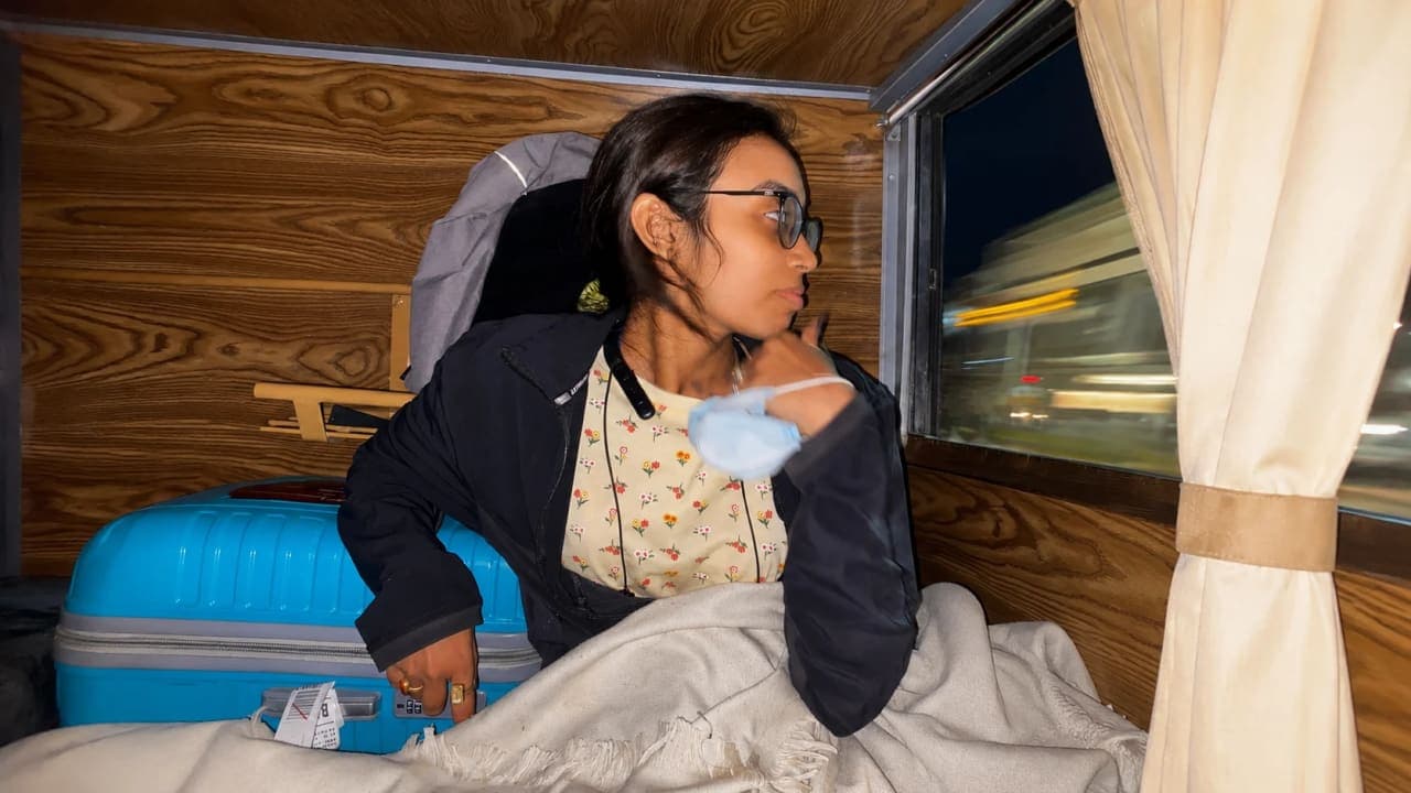 Passenger relaxing inside a sleeper bus cabin while travelling overnight to a beach destination.
