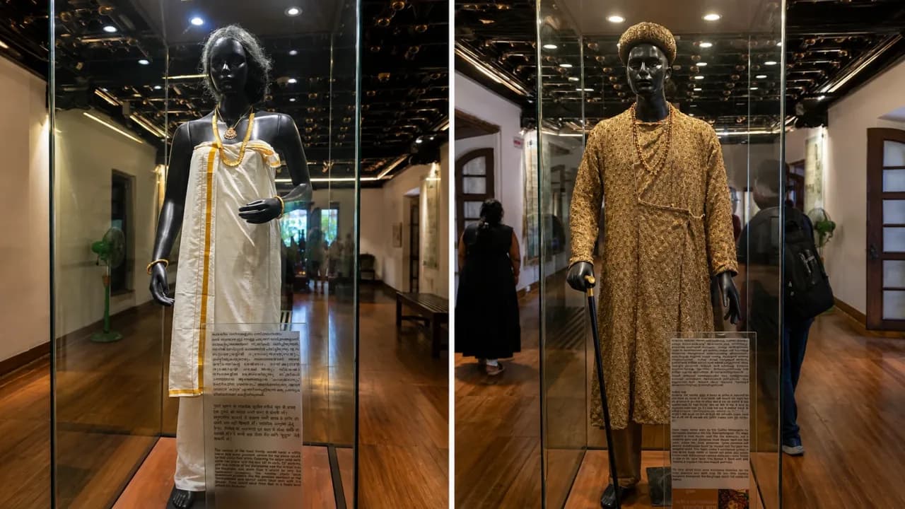 Traditional royal costumes displayed inside glass cases at Mattancherry Palace museum in Kochi, showcasing the clothing and ornaments associated with Cochin's royal heritage.