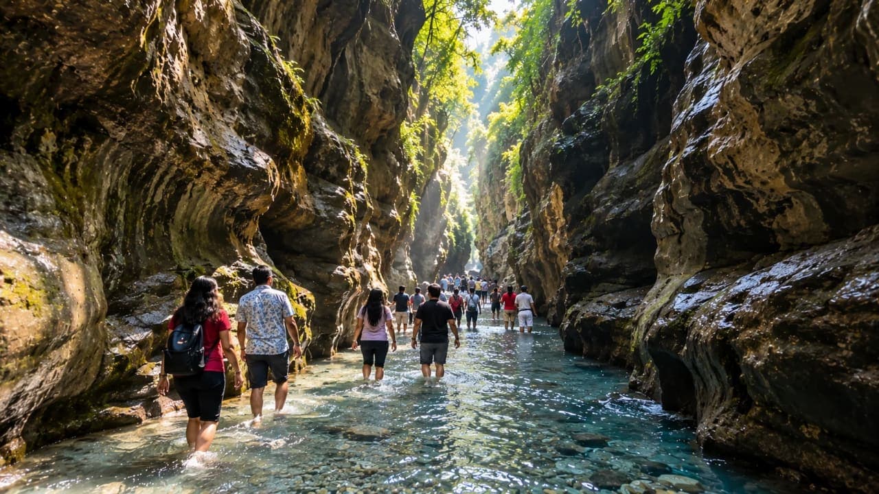 Visitors walking through shallow water inside Robber’s Cave at Guchhupani in Dehradun.